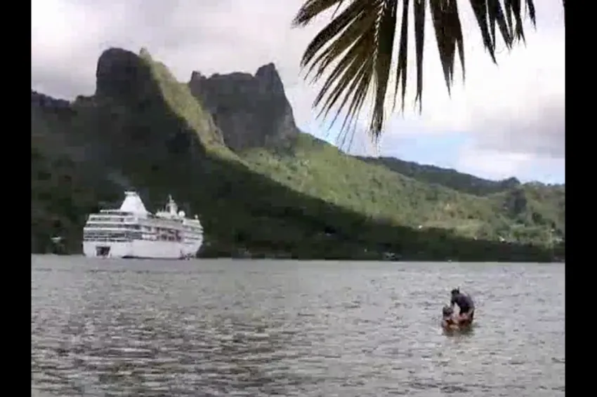 two people in the water with mountains in the background