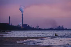 Swimmers brave the waters in the shadow of a coal-fired power plant.  Coal plants like this one emit CO2 into our atmosphere which is warming the planet and altering the chemistry of the ocean.