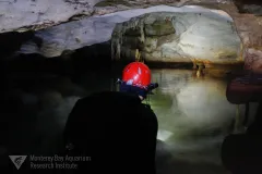 a man with a hard helmet in a cave