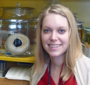 Hannah Waters with preserved giant squid eye next to her.