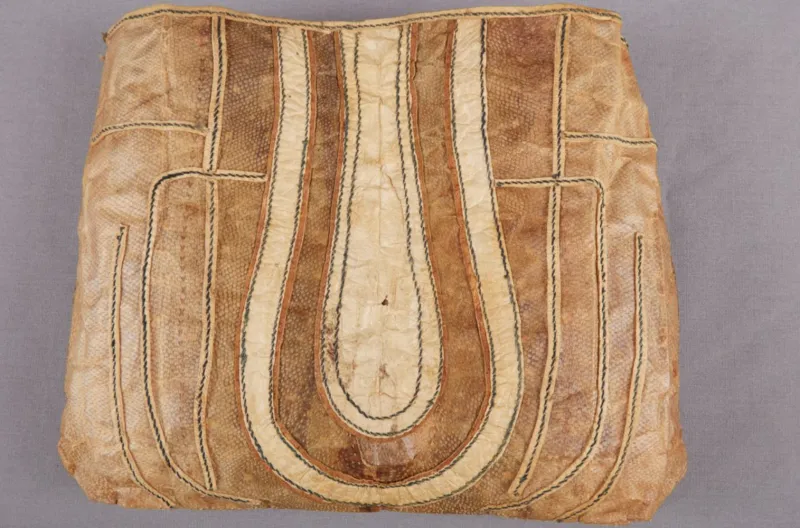 A brown fish skin bag with stitched, organic designs.