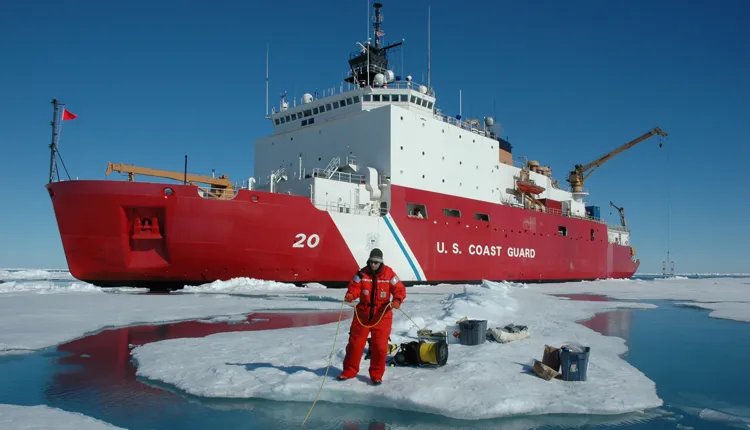 A dive tender monitors divers below the ice.