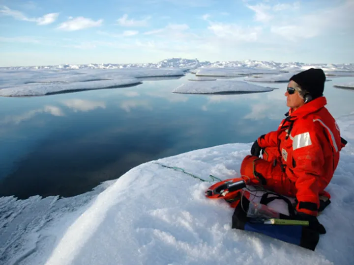A marine mammal scientist listens for bowhead whales using an underwater hydrophone.